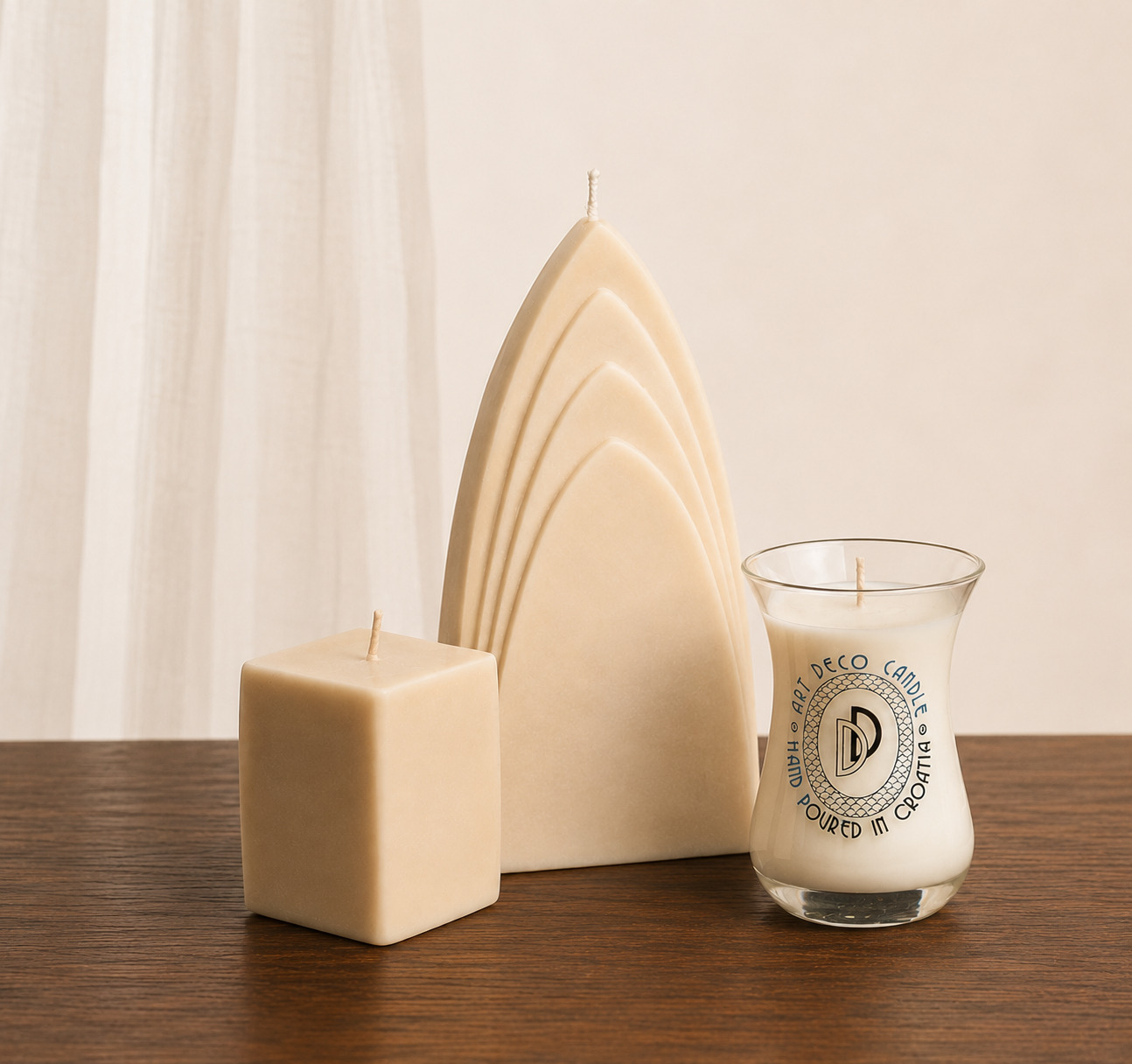 Three handcrafted candles displayed on a wooden surface