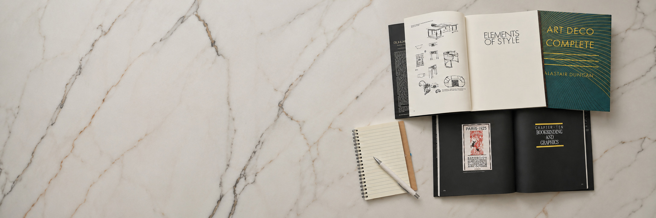 Open Art Deco books arranged on a marble surface